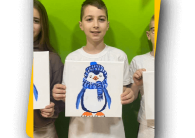 Kisfiú boldogan mutatja elkészült festményét.